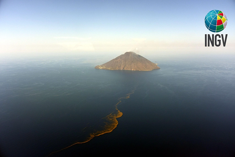 L'isola di Stromboli due giorni dopo il parossisma del 3 luglio 2019. Una parte dei prodotti emessi durante l'eruzione è costituita da materiale galleggiante che, ricaduto in mare aperto, forma una scia marrone giallastro trasportata dai venti e dalla corrente (foto di Stefano Branca). - Uno - Galleria