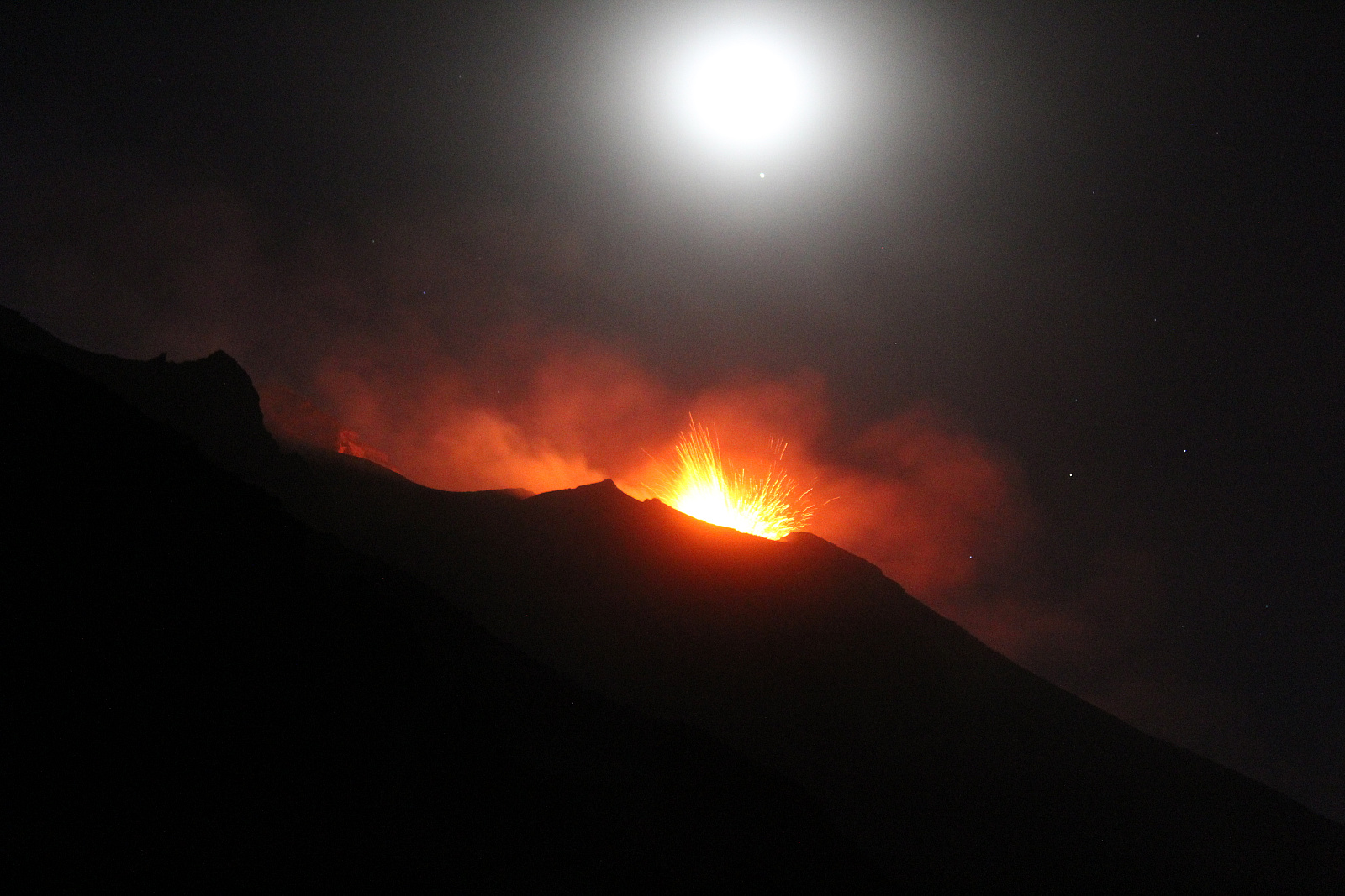The Moon looks out the clouds over Stromboli volcano (Aeolian Archipelago, South Mediterranean) during the effusive eruption of summer 2019. - Pictures