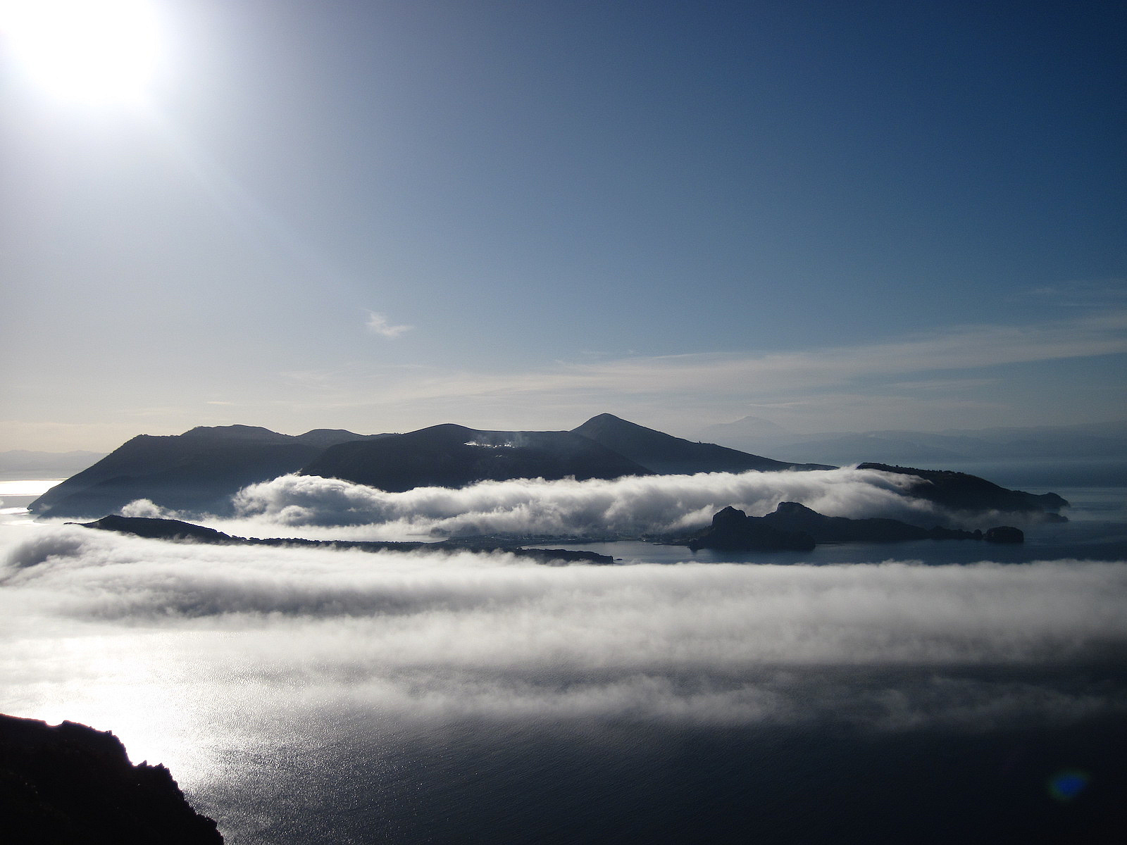 Vulcano island (Aeolian Archipelago, South Mediterranean) wrapped by the fog in wintertime. On the background, Mt. Etna. - Pictures